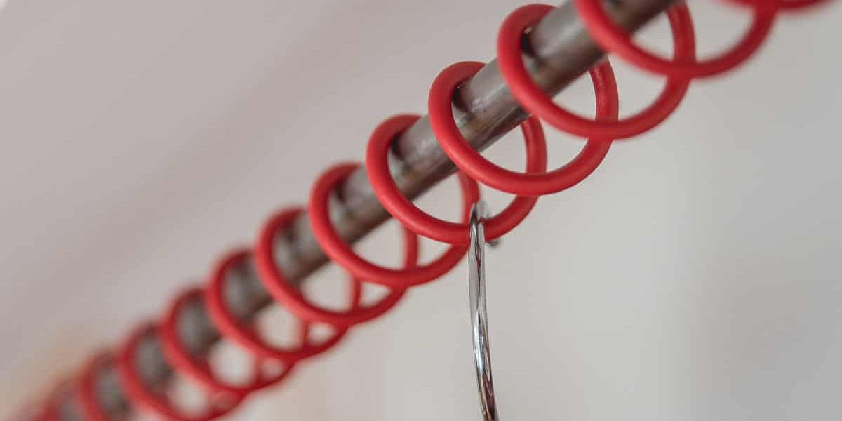 Close up of a red Zebedee railing with a clothes hanger attached.