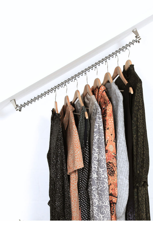 A Zebedee Original Hanging Rail with garments hanging on it, showcasing the ability of the rail to hold items at various angles.