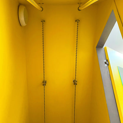 Yellow angled closet with Zebedee yellow  sloping clothes rails and a door on the right side