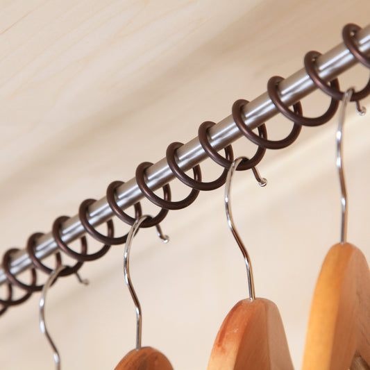 Close up product image of Zebedee Bronze any angle wardrobe rail on a beige back ground.