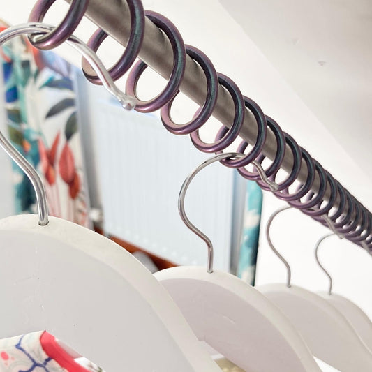 Sloping clothing hangers with a metal rod and colorful background