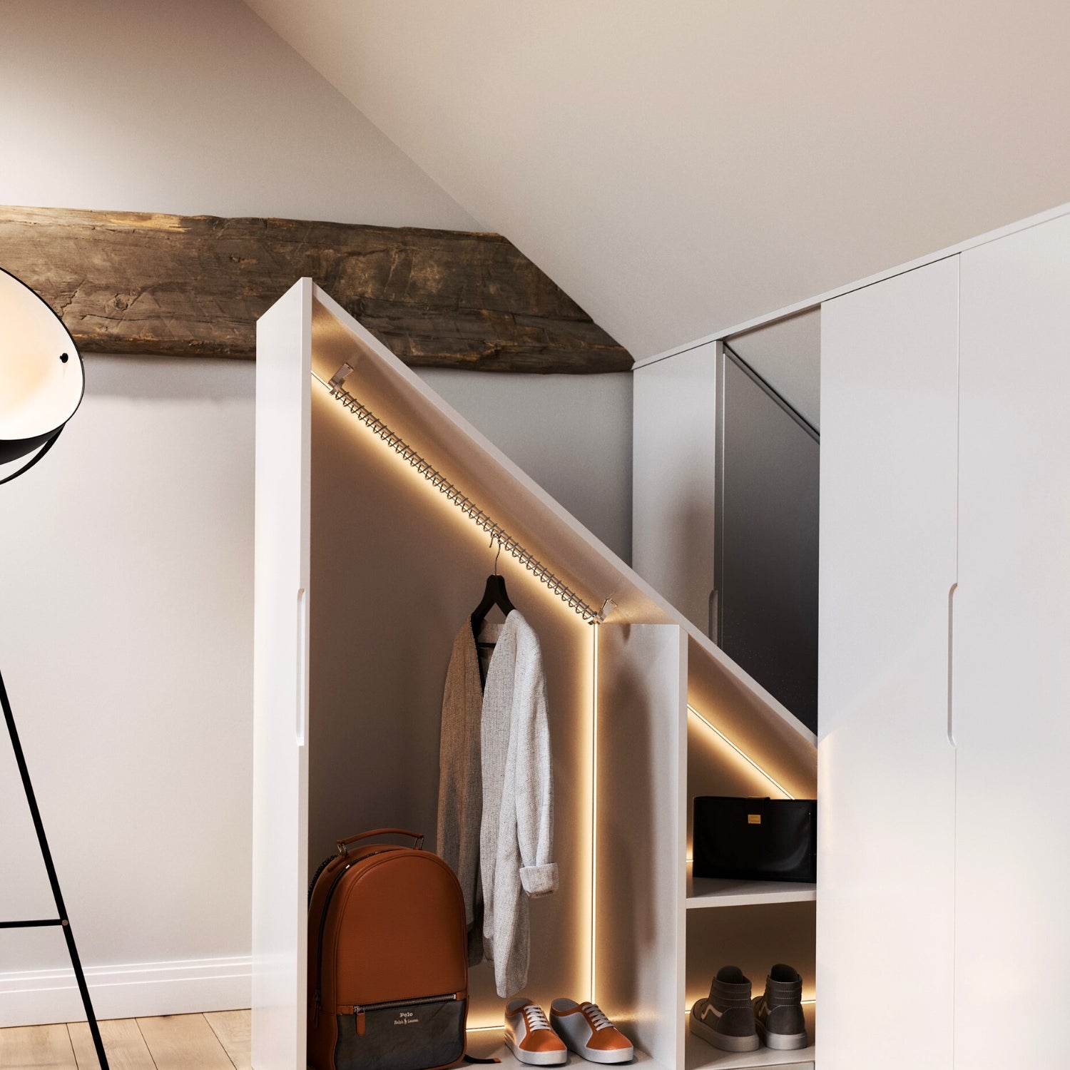 Modern interior with an angled pull out pod wardrobe, sloped clothes rail, shoes, and a backpack illuminated by LED lights.