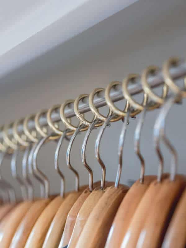 Zebedee Any Angle Hanging Rail - Brass - Shown with coat hangers